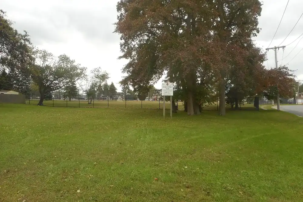 Open grassy field with mature oak trees at the Fort Massapeag site in Massapequa, New York