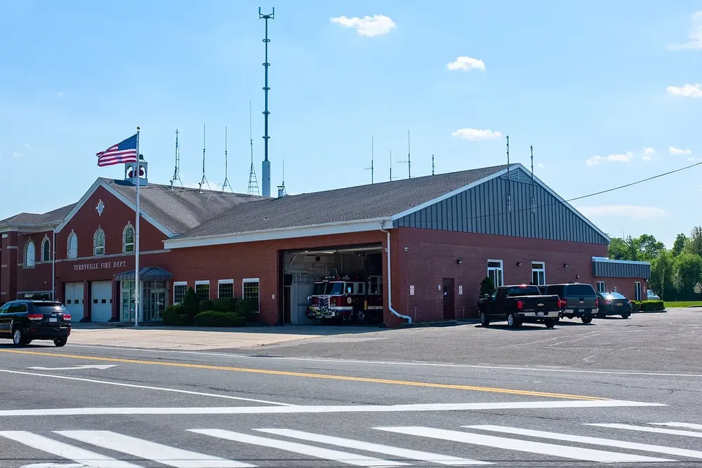 Terryville fire department building with a flagpole and tall antenna tower in Terryville, New York